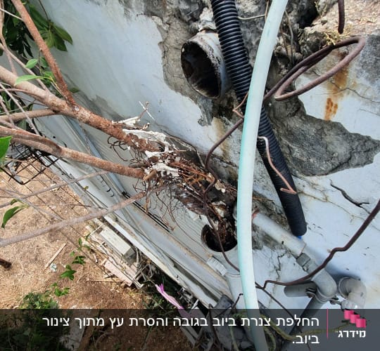 אדם עובד עם צינורות וכלי עבודה על קיר בטון